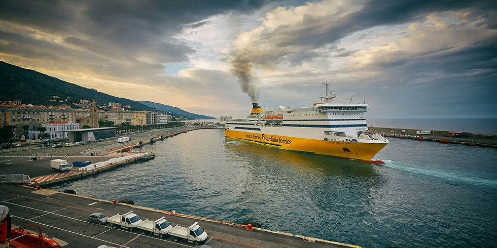 Un ferry jaune avec "corsica ferries" quitte le port sous un ciel nuageux, de la fumée s'échappe de sa cheminée. Ville côtière en fond.