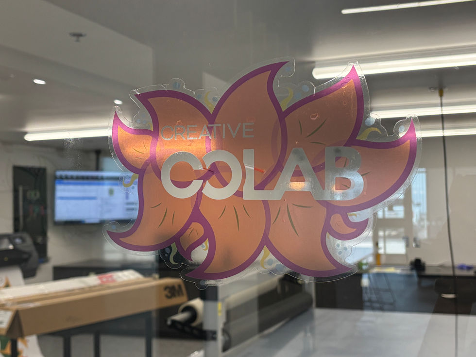 An orange flower decal hanging on a window.