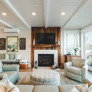 interior remodel of a living room featuring a wooden fireplace, wooden floors and white wooden faux ceilings