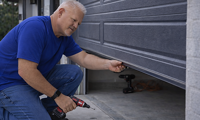 Garage door repair technician fixing residential garage door in Houston