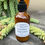 Thumbnail: Bottle of Cocoa Butter Body Lotion on teak table with orange pot and succulent