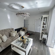 Contemporary living room with grey sofa white coffee table and glass chandelier