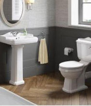 Small bathroom with a sink, toilet seat and an oval mirror