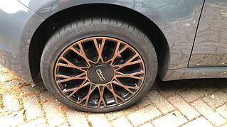 Close-up of a bronze alloy wheel with a black centre cap featuring the Fiat logo
