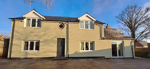 Freshly rendered white house with new black-trimmed windows