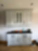 Built-in white kitchen wall cabinets mounted above a dark laminate countertop