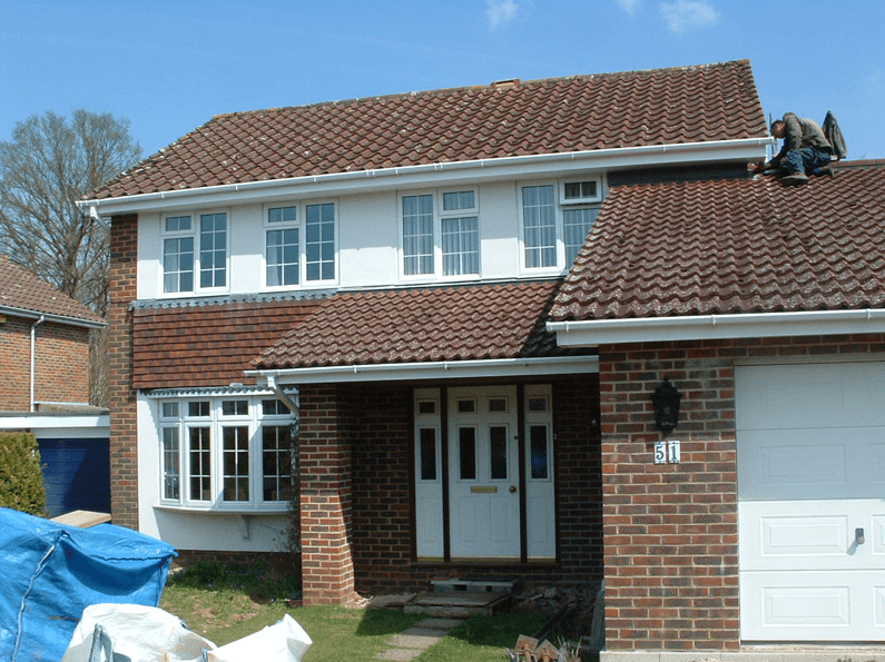 Front view of a brick house with a tiled roof and large windows