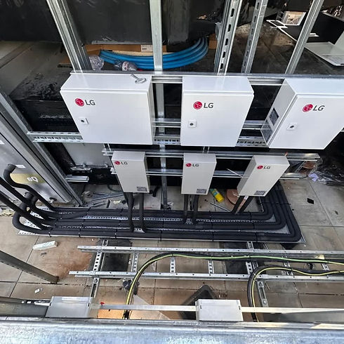 LG HVAC electrical control boxes and insulated refrigerant piping mounted on metal frames