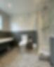 A bathroom with grey and white bricked wall