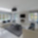 Modern living room with two white sofas, a table on a grey rug, and a wall-mounted TV above a sleek fireplace