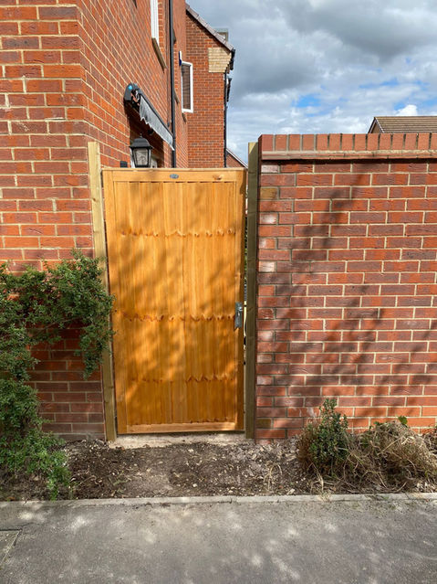 A newly constructed wooden door between the brick wall