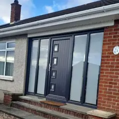 A modern residential entrance featuring a dark grey door with glass panels