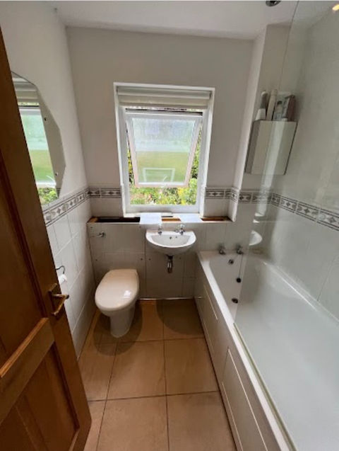 A bathroom with wooden flooring and fixed plumbing