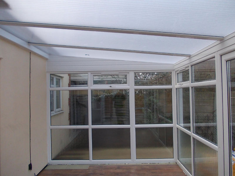 A bright sunroom with white framing and large glass windows