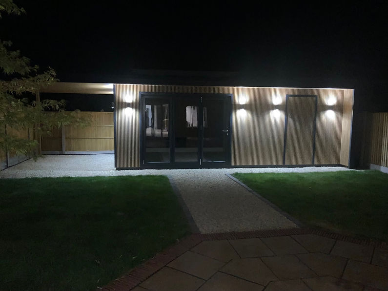 A modern wooden building illuminated at night with exterior lights
