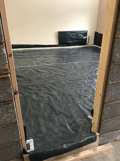 A room under construction with damp proofing covering the floor