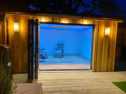 Outdoor wooden shed with a sliding door and lighting