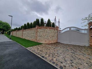 A bricked driveway with a white door and bricked wall