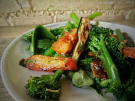 A colourful plate of sauteed vegetables, including broccoli, and leafy greens