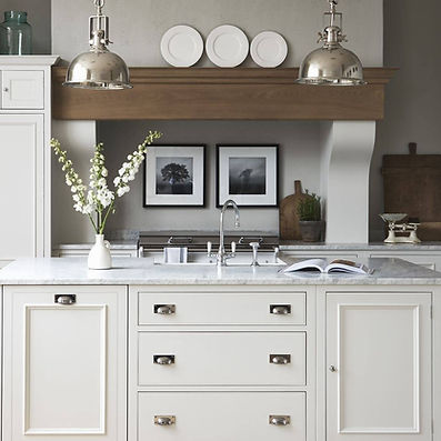 Bright, modern kitchen with white cabinets, marble-topped island, and two wooden high chairs