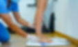 Gloved hands measuring and assessing a patient's bare foot during a clinical biomechanical assessment