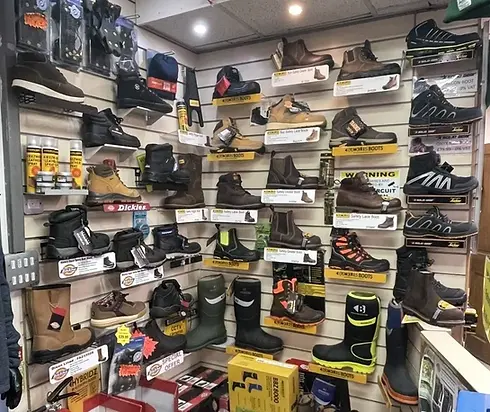 A variety of boots displayed on wall shelves in a store