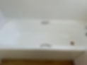 A clean, white bathtub with silver fixtures against tiled walls