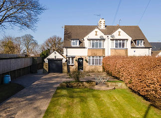 A two-story house with a stone facade, black garage door, and a neatly trimmed lawn