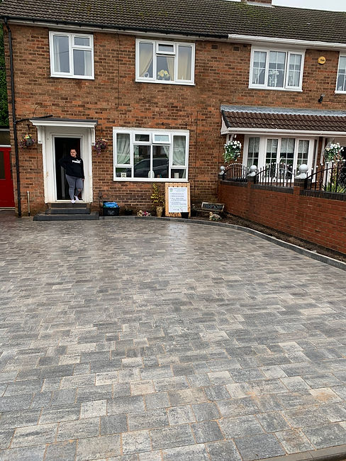 A driveway of a house with a white door and a window