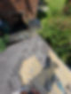 Overhead view of roofers installing new grey slate tiles on a residential building roof