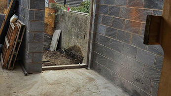 Construction site with unfinished walls and doorway reveals an outside space