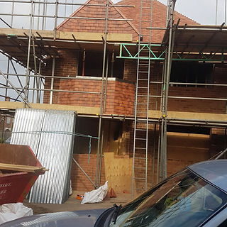 External brick chimney stack and roof structure surrounded by metal scaffolding for repair work