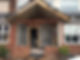 The front porch under construction with brick and block walls and a wooden framework