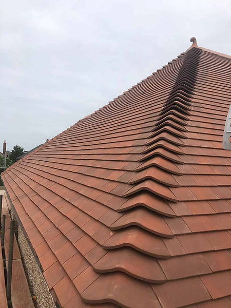 Steep red clay tile roof with neat, uniform rows, creating a textured pattern