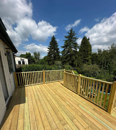 Wooden deck with railing surrounded by trees