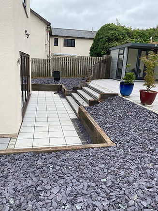 A patio with a stone walkway and a building