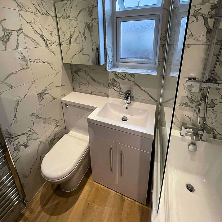 Marble tiled bathroom with modern toilet, floating vanity cabinet and shower mixer tap
