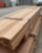 Stack of wooden planks tightly bound with a metal band, situated on a pallet outdoors