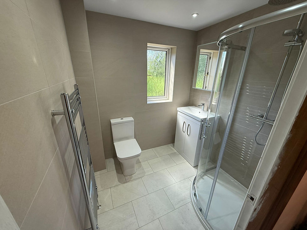 Modern bathroom featuring a shower cubicle, toilet, sink cabinet, and heated towel rail