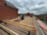 Wooden roof trusses being constructed on a building site