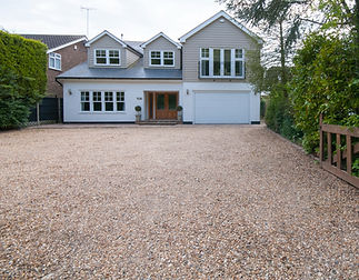 Gravel driveway of a house with white windows