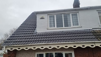 A house roof with grey tiles and decorative white trim