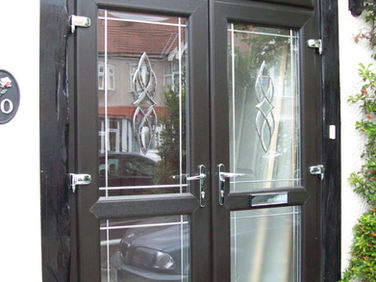 A modern black double door with decorative glass panels