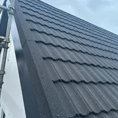 Metal roof tiles with matching dry verge trim and construction scaffolding