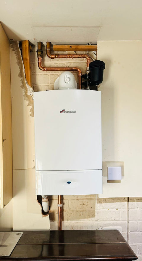 Uncovered plumbing pipes attached to a boiler