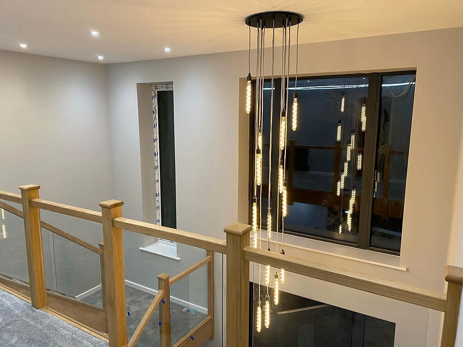 Modern interior with a wooden and glass staircase, illuminated by a contemporary hanging l
