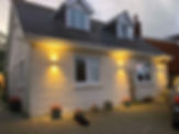 Exterior view of a white house with warm lights