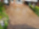 A clean, patterned concrete driveway in front of a brick house