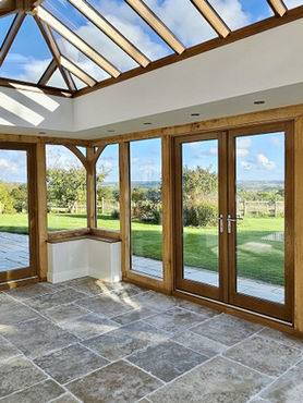 Bright conservatory with wood frames and stone tile flooring