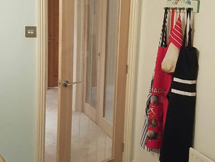 Oak doors fitted near coat hooks in a hallway